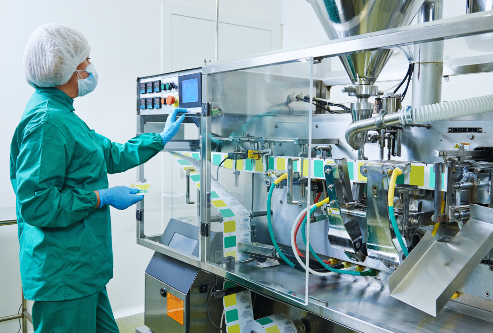 A factory technician using an AI-driven predictive maintenance dashboard on a computer screen, analyzing real-time machine performance data to prevent unexpected breakdowns and lower maintenance costs.